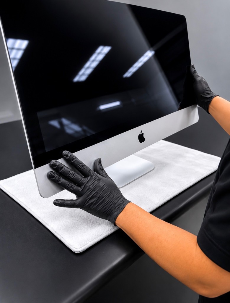 Technician refurbishing an iMac on a protected work surface