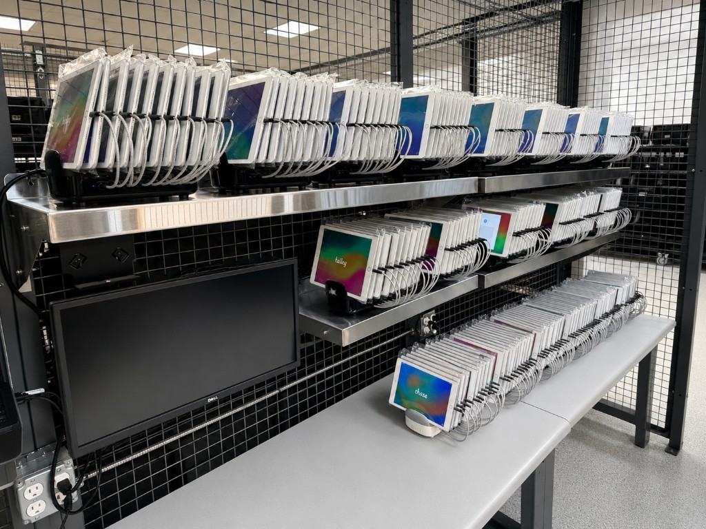 Rows of tablets on charging docks at a setup and configuration station